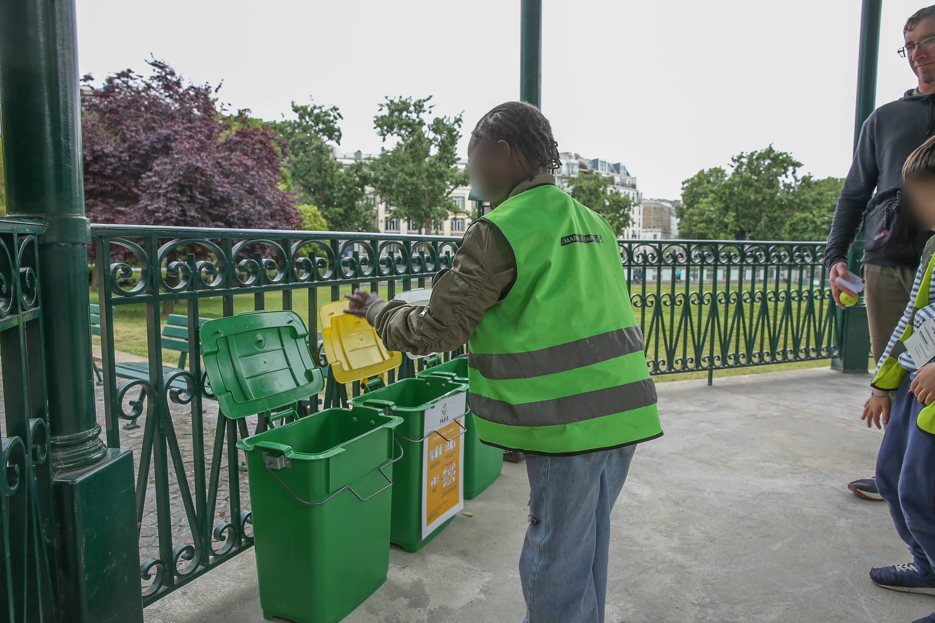 Enfant en train de jeter les déchets dans des poubelles