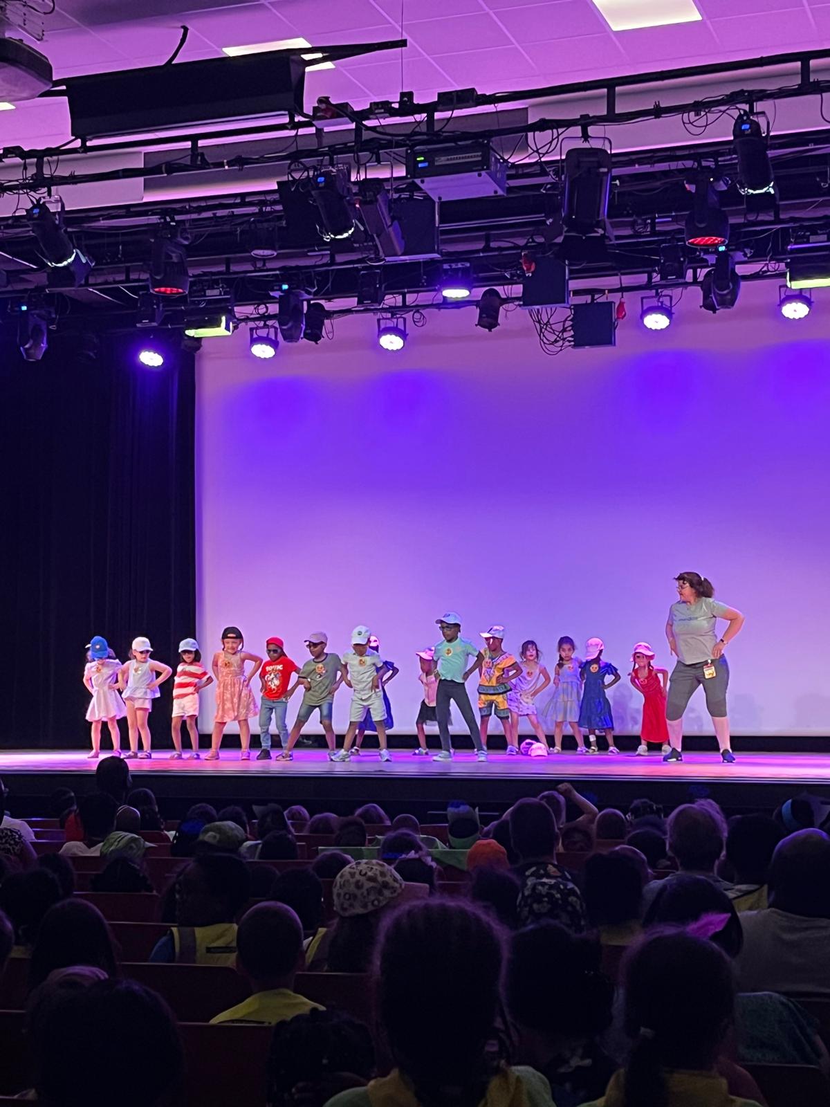 Des enfants et une animatrice en pleine démonstration de danse