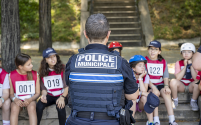 Une policière municipale debout devant des enfants