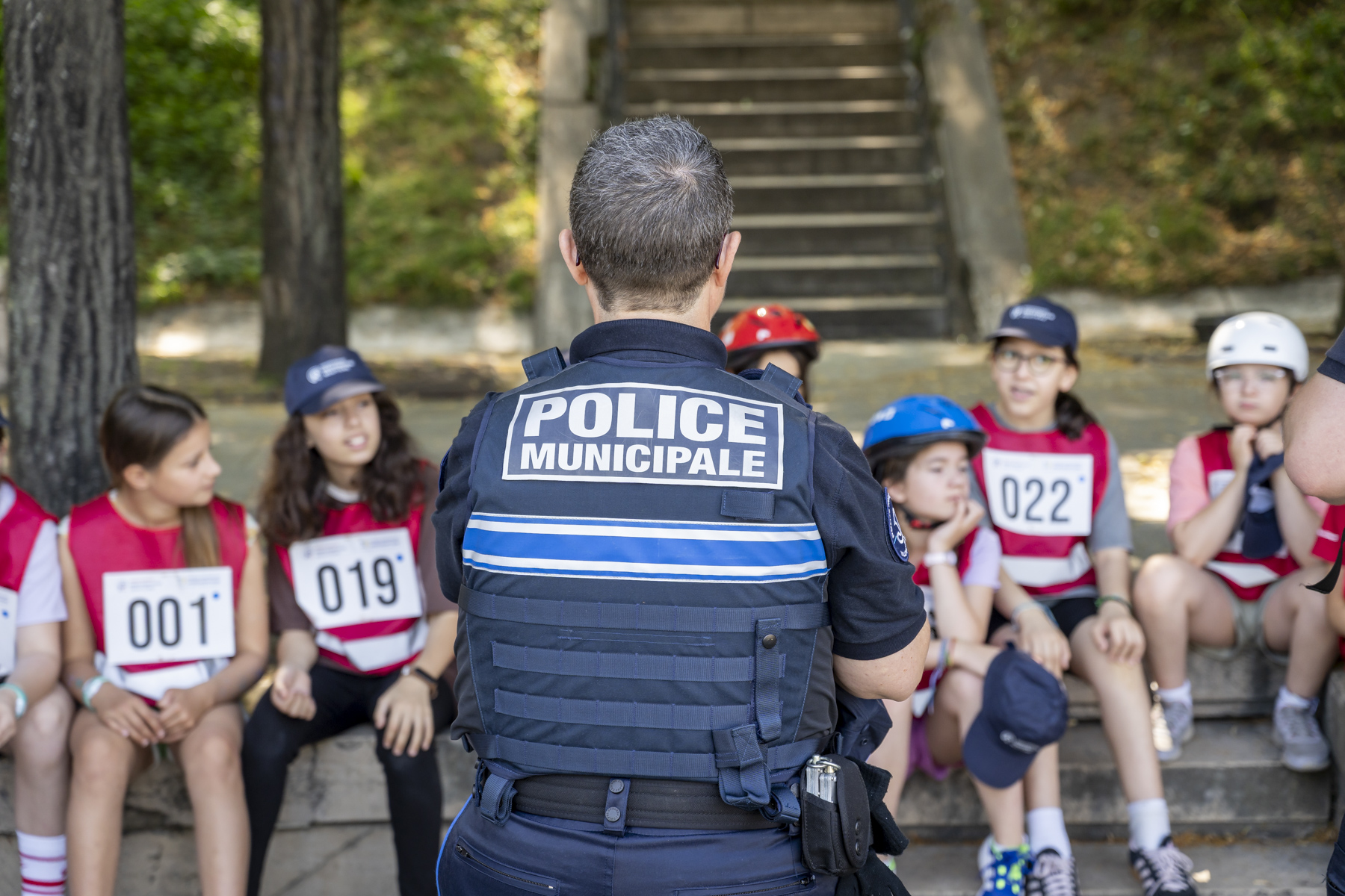 Une policière municipale debout devant des enfants