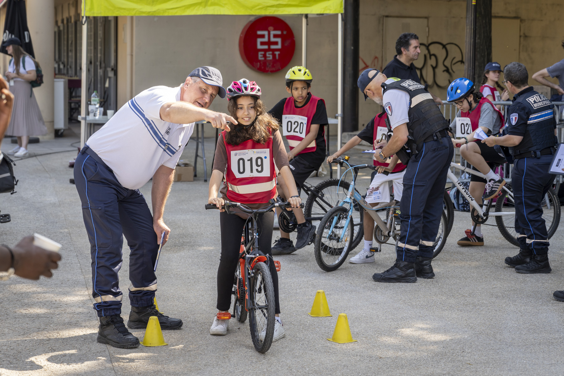 une enfant à vélo et un policier municipal