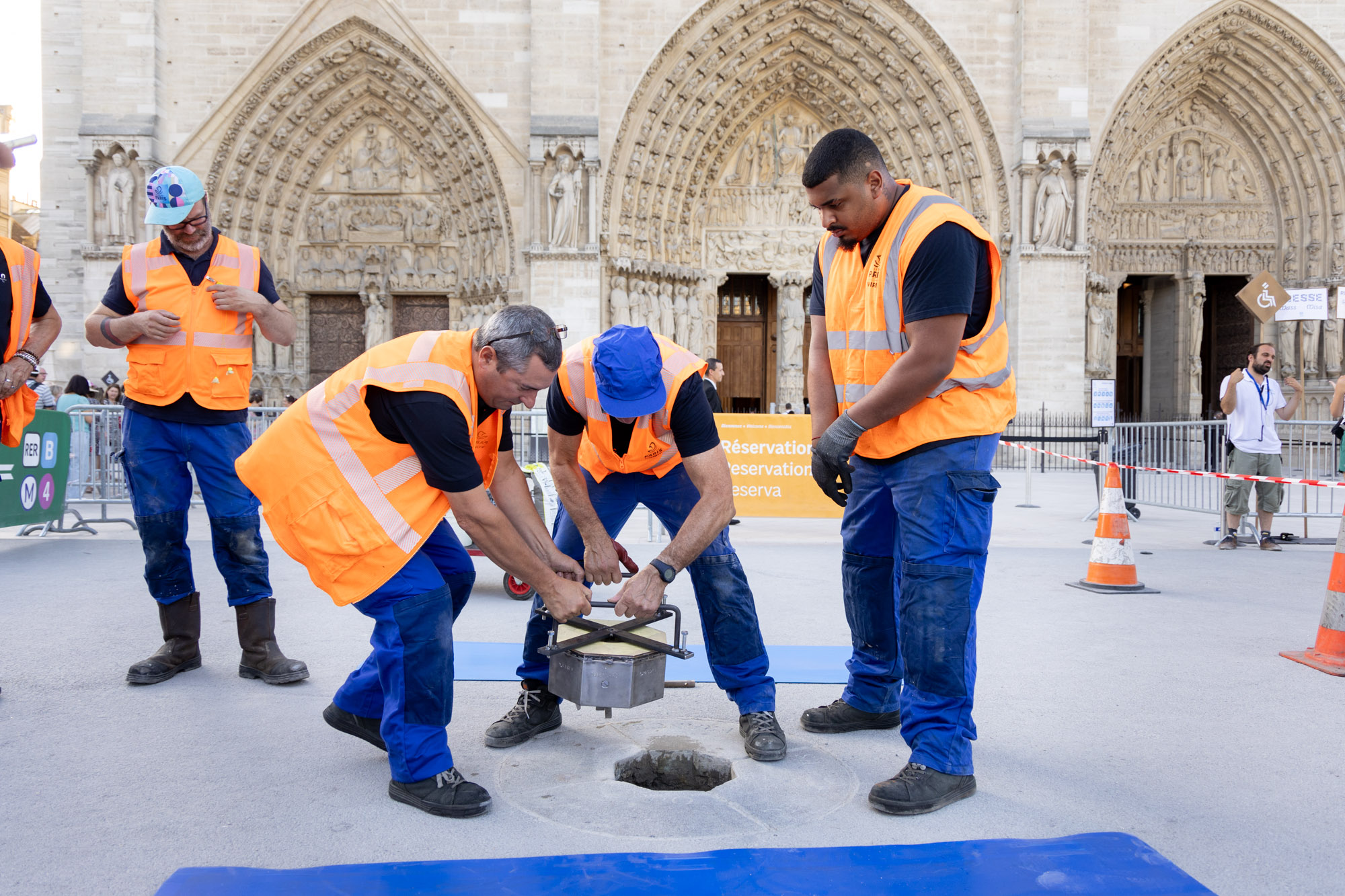 Une équipe s'affaire à installer le nouveau point Zéro sur le parvis de Notre Dame.