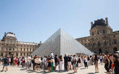 La pyramide du Louvre, entourée de touristes. 