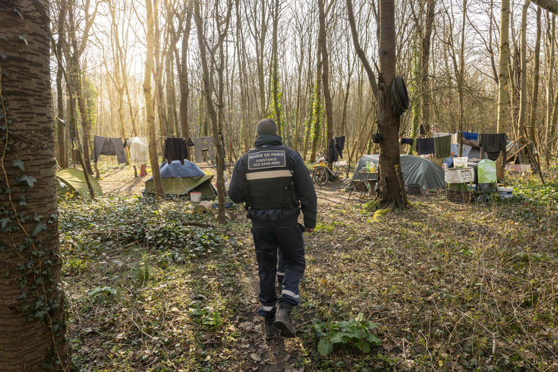 une agent de prévention de la ville de Paris dans un bois, aux abords d'un campement