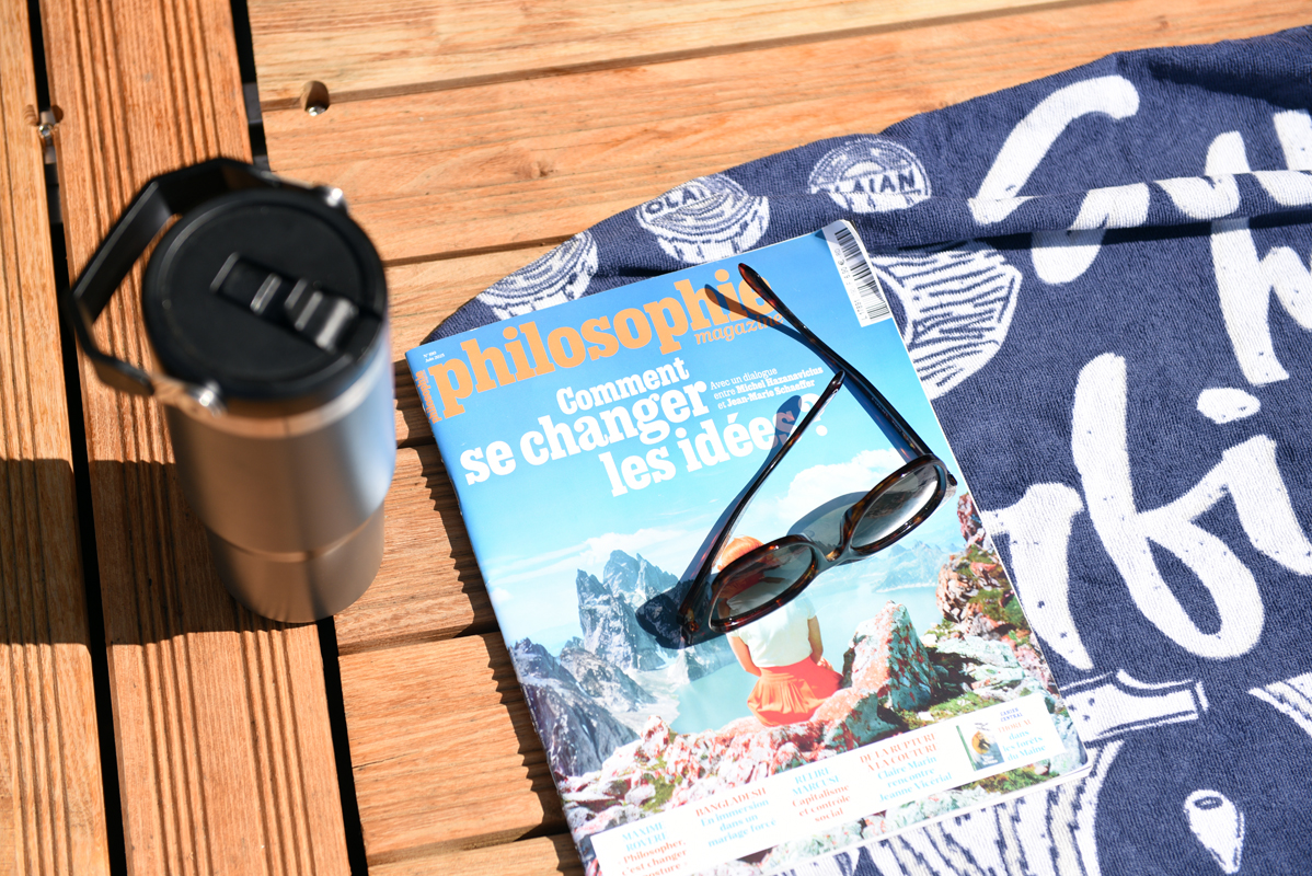 Philosophie magazine, une gourde et une paire de lunette de soleil sur la serviette de bain d'un utilisateur du site de baignade de Grenelle. 