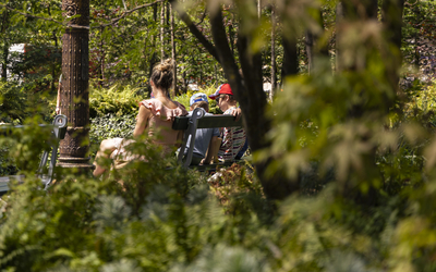 Des personnes se reposent sur les bancs de la foret urbaine.