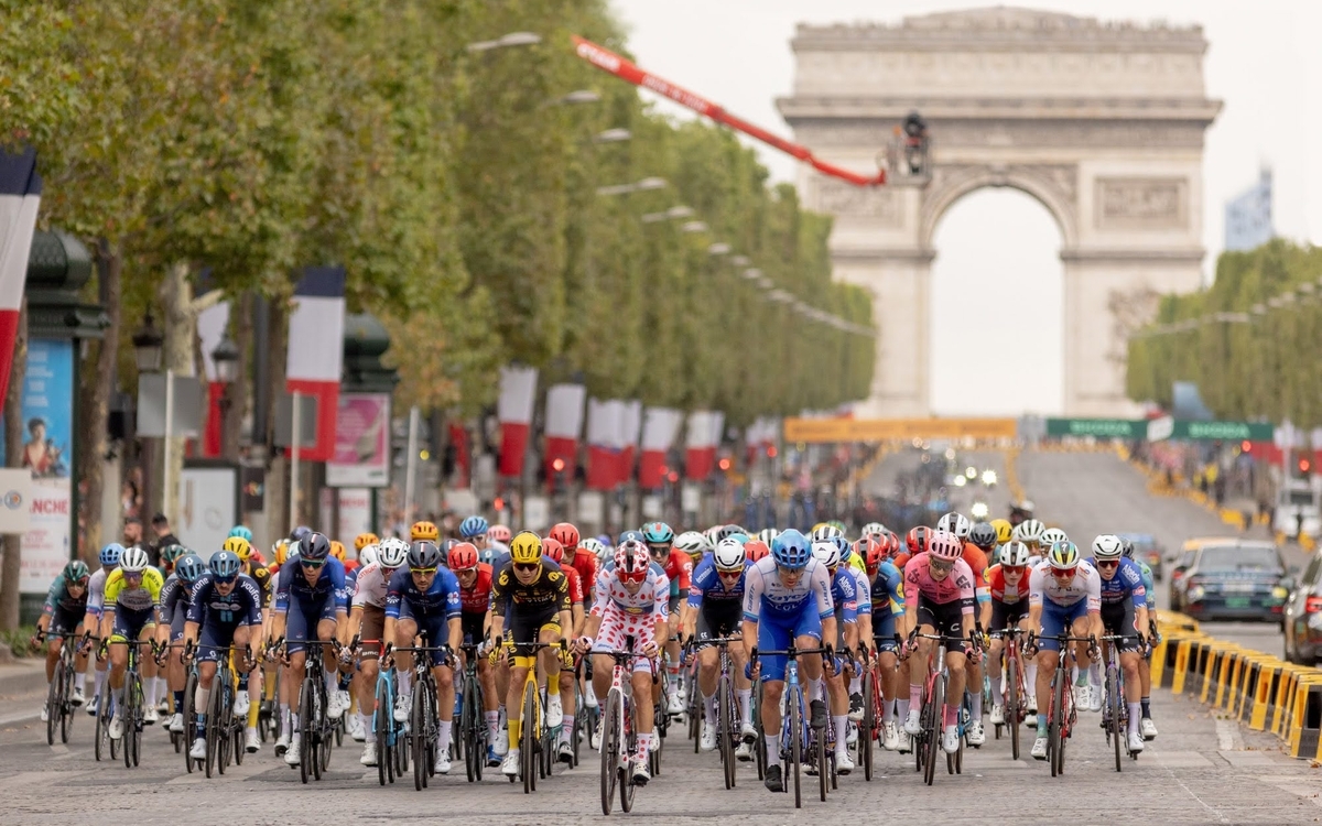 Groupe de cyclistes descendant l'avenue des Champs-Elysée,s avec l'Arc de triomphe en fond