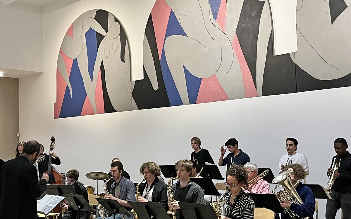 Des musiciens jouent devant une peinture de Matisse