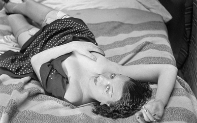 Kiki de Montparnasse, modèle français., allongée sur un lit.