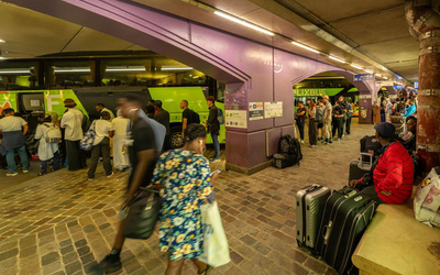 Des bus en chargement de passagers dans une gare routière en sous-sol particulièrement fréquentée