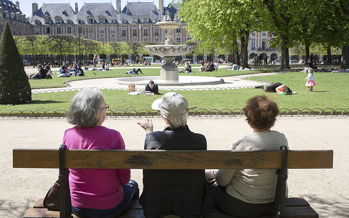 Trois femmes âgées sont assises sur un banc du Parc de la place des Vosges lors d'une chaude après midi d'été