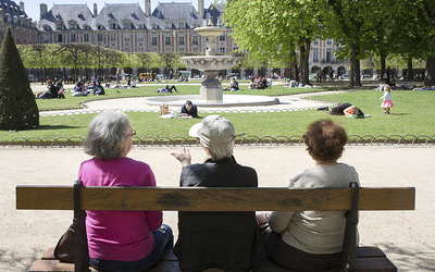 Trois femmes âgées sont assises sur un banc du Parc de la place des Vosges lors d'une chaude après midi d'été