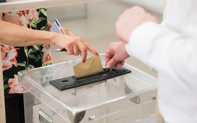 femme en train de mettre son bulletin de vote dans l'urne