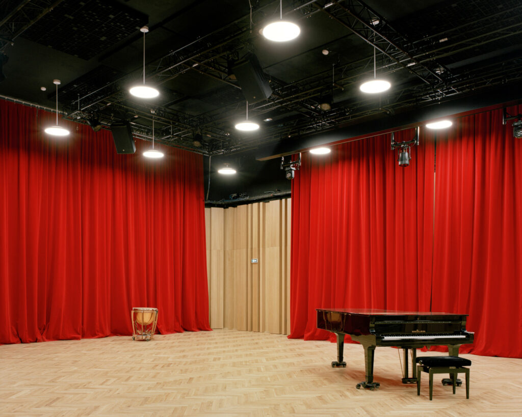 Vue d'une salle de répétition avec piano et rideaux rouges