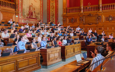 Des personnes assisent dans la salle du conseil