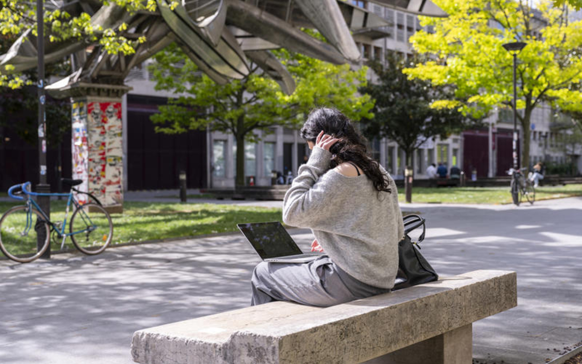 Ado travaillant sur ordinateur en exterieur