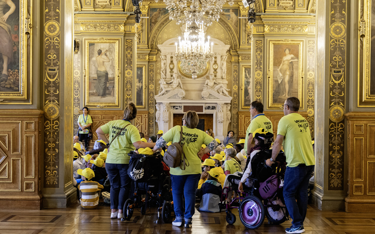 Des enfants et des adultes dans une salle de l'hotel de ville