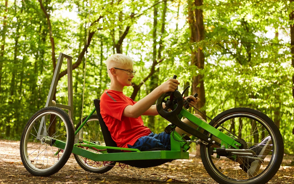 Photo d'un jeu garçon unijambiste sur un vélo à main (vélocimane)