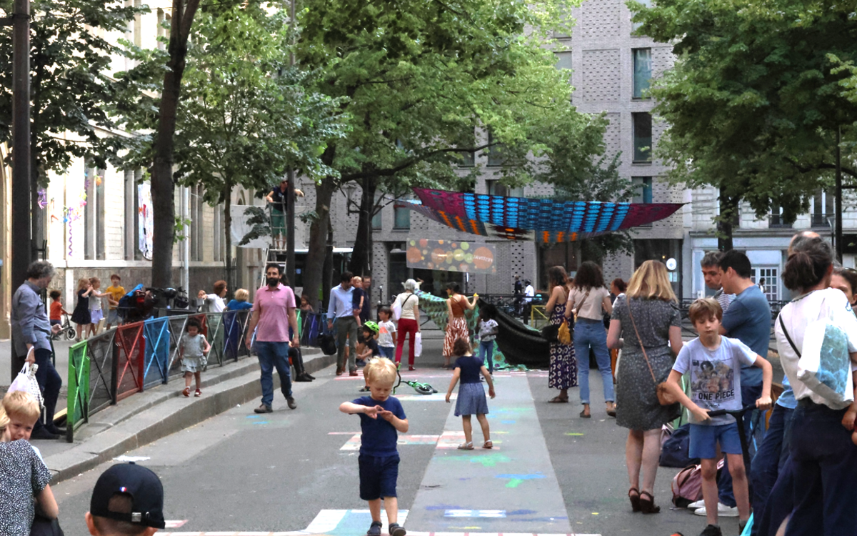 Des enfants jouent dans une rue piétonne lors d 'une fête rassemblant toutes les générations