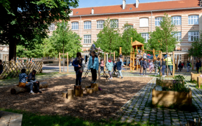 Des enfants jouent dans une cours végétalisées, ombragées