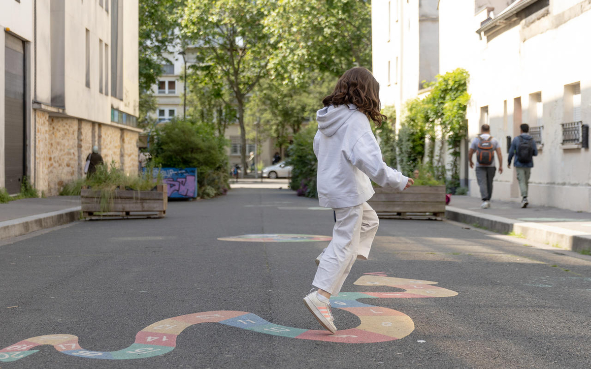 Fillette qui saute sur une marelle