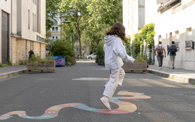 Fillette qui saute sur une marelle