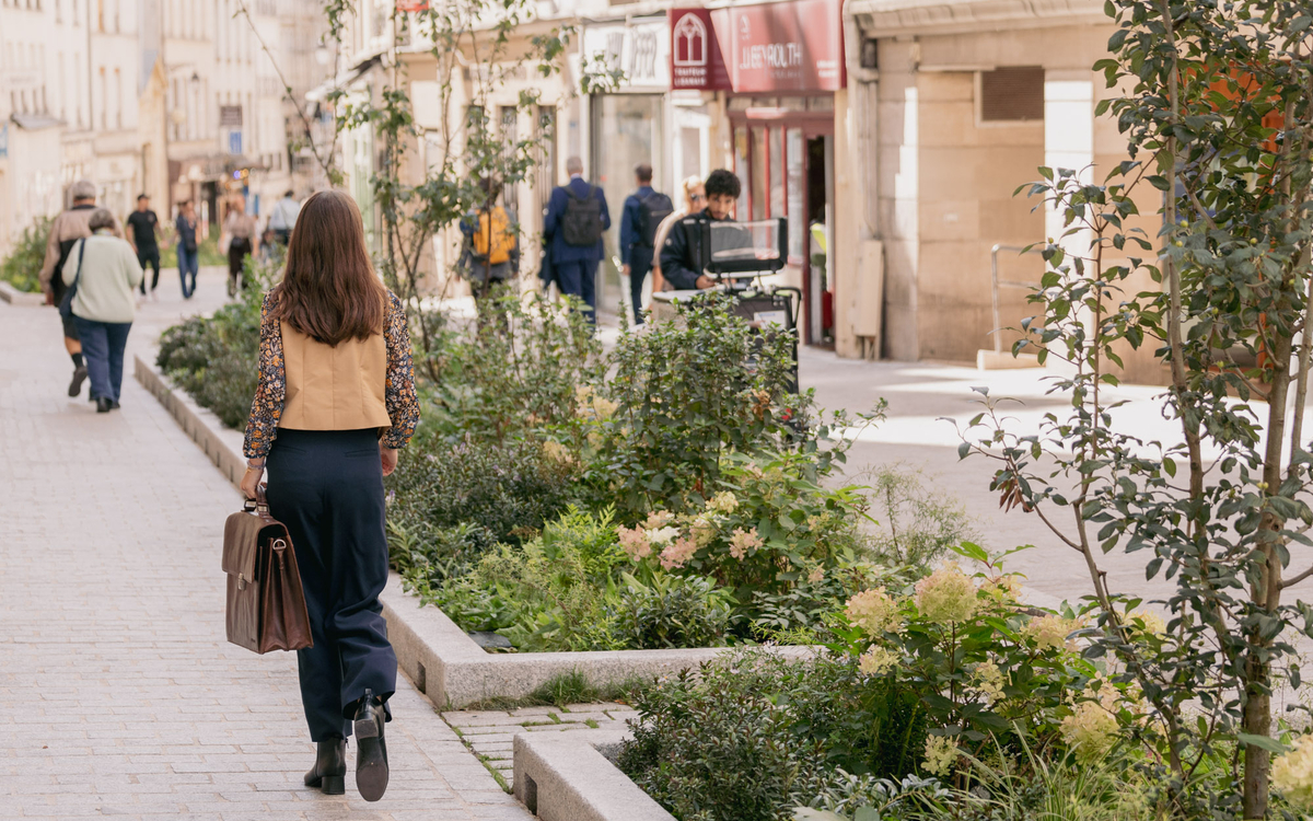 Une personne se promène dans la rue Mouffetard, végétalisée et piétonnisée.