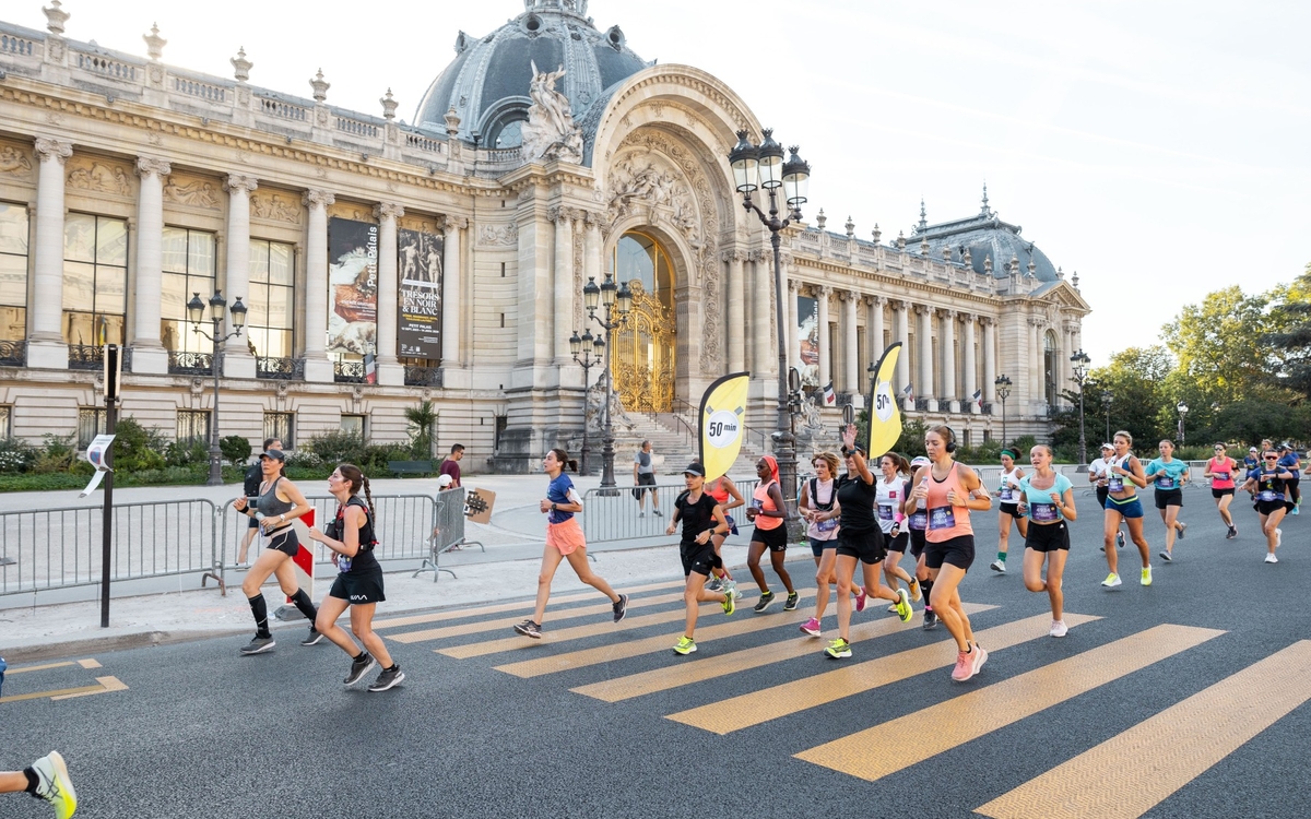 Une groupe de personnes courant devant le Petit Palais