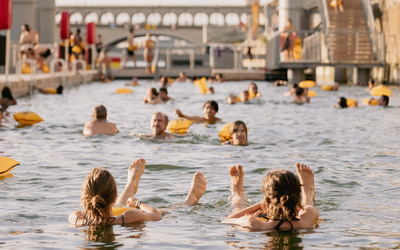 Deux personnes, les doigts de pieds en éventail dans le bassin de la baignade de Bercy.