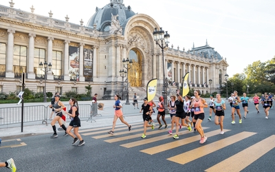 Une groupe de personnes courant devant le Petit Palais