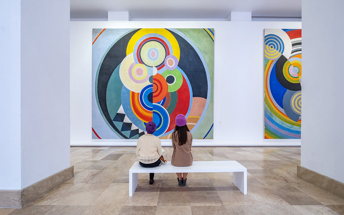 Deux personnes regardant un tableau dans un musée.