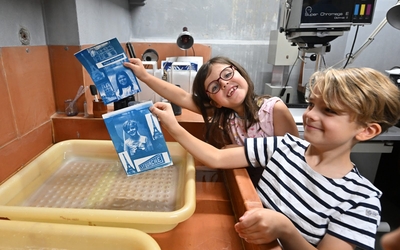 deux enfants montrent les cyanotypes qu'ils ont réalisé