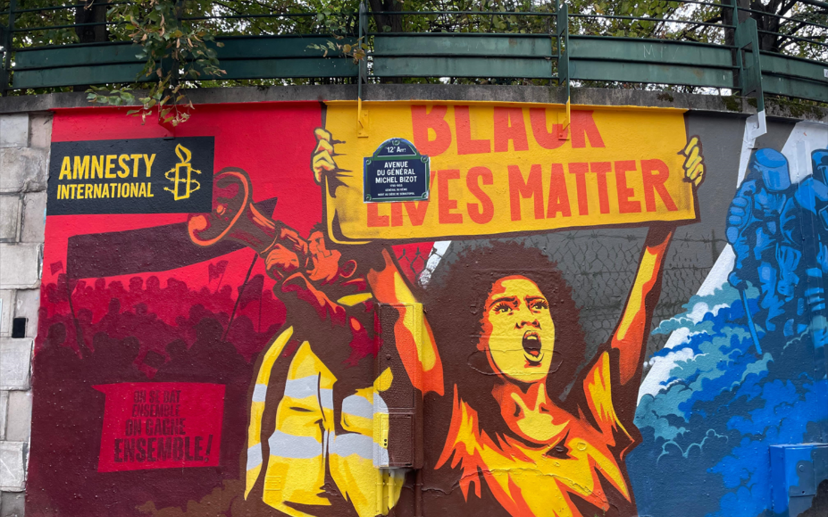 Une fresque de streetart représentants des manifestants portant des gilets jaunes ou arborant une pancarte Black Lives Matter