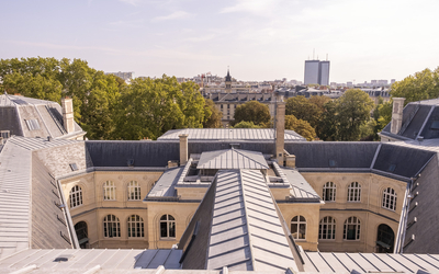 Photo des toits de la mairie du 20e vue depuis le campanile. L'hôpital Tenon au loin.