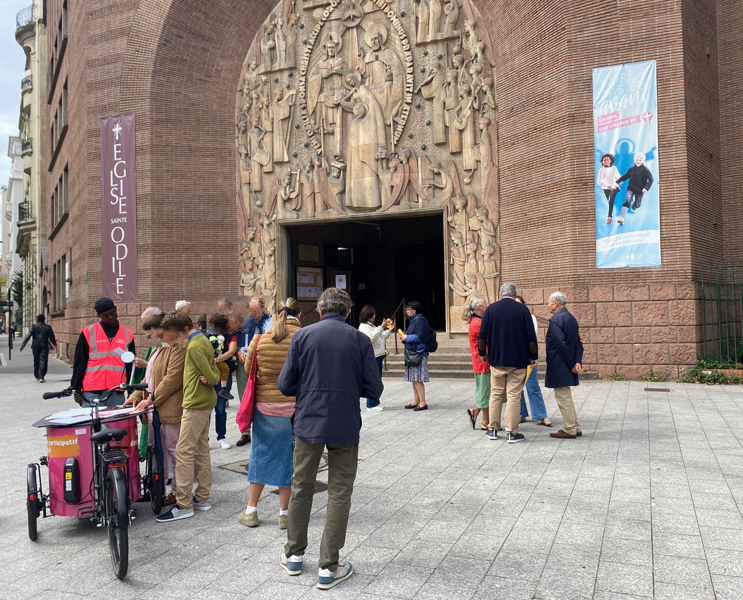 Photo du Budget Participaitf des gens entrian de voter autour de l'urne devant Sainte-Odile