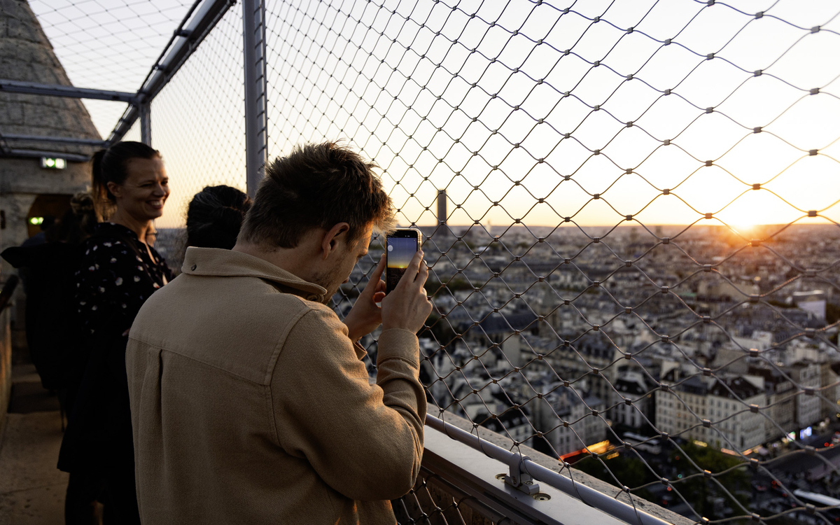 Des visiteurs admirent Paris depuis les tours de la Cathédrale Notre-Dame.