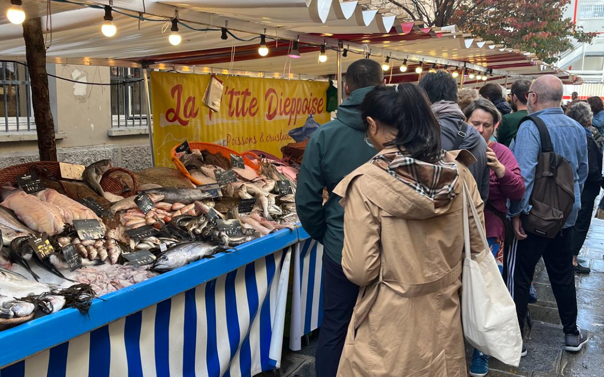 Des clients au stand poissonnerie du marché Sainte-Cécile qui se situe sur la rue Sainte-Cécile et la rue du Conservatoire dans le 9e.