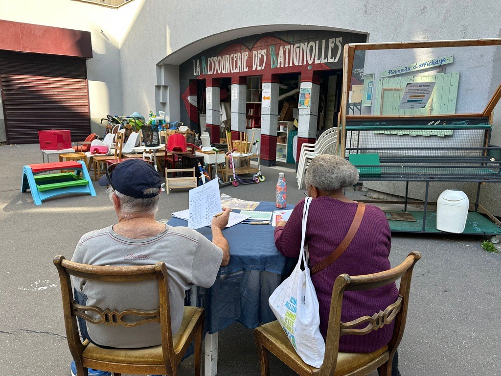Photo de deux personnes assises, vues de dos, en train de voter au Budget Participatif