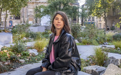 Femme châtain assise sur une pierre en granit