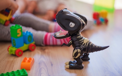un dinosaure en plastique sur du parquet 