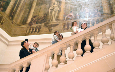 Des enfants et leur parent montent les escaliers du musée Carnavalet. 