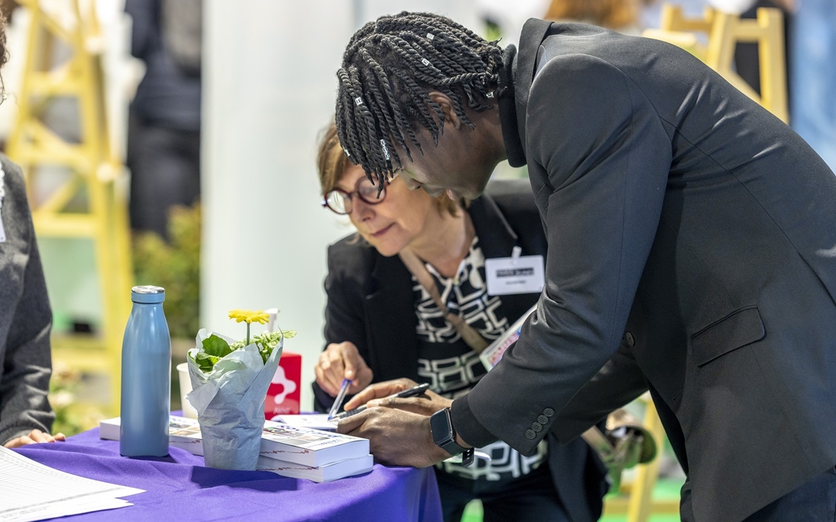 Un jeune remplit un formulaire d'embauche lors du salon Paris pour l'emploi