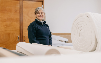 La tapissière pose devant des tissus