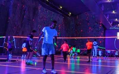 Partie de badminton dans le noir avec lueurs fluo 