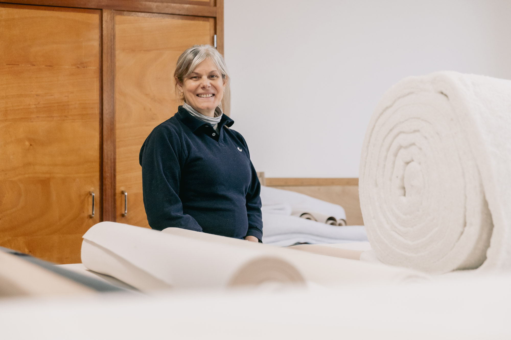 La tapissière pose devant des tissus