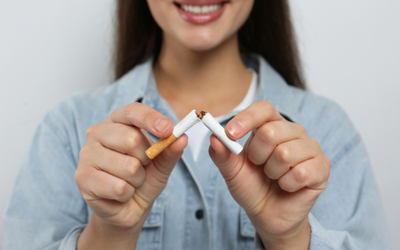 une jeune femme cassant une cigarette en deux