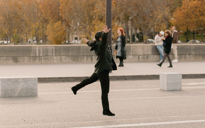 Une personne danse de joie dans la rue. 