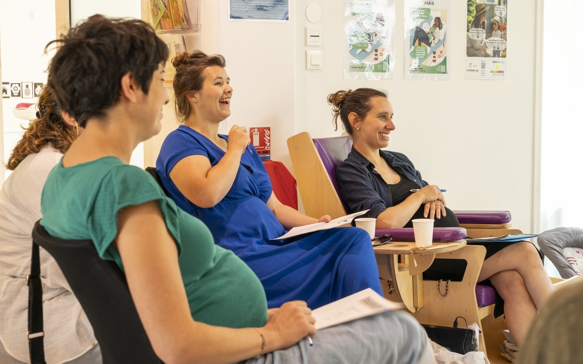 trois femmes enceintes aux visages réjouis installées dans des fauteuils lors d'une réunion d'information