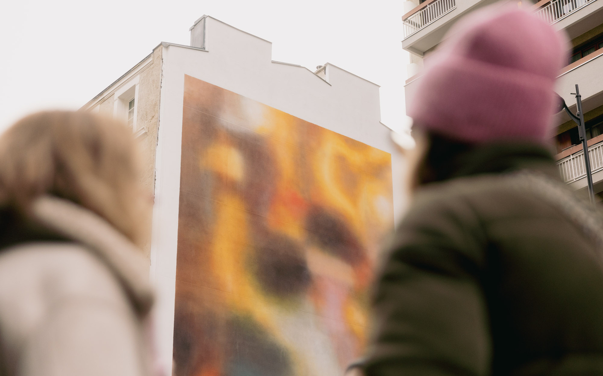 Deux personnes regardent la fresque en hommage aux victimes des attentats du 13 novembre 2015