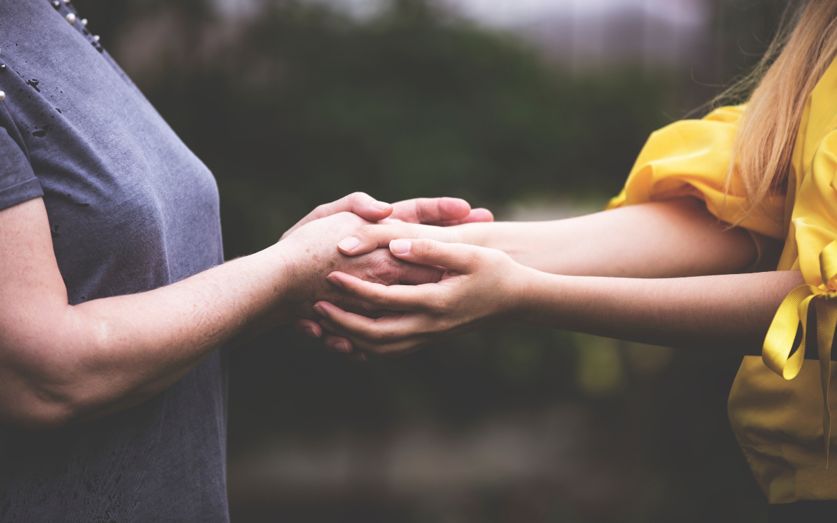 Deux femmes se tenant les mains.